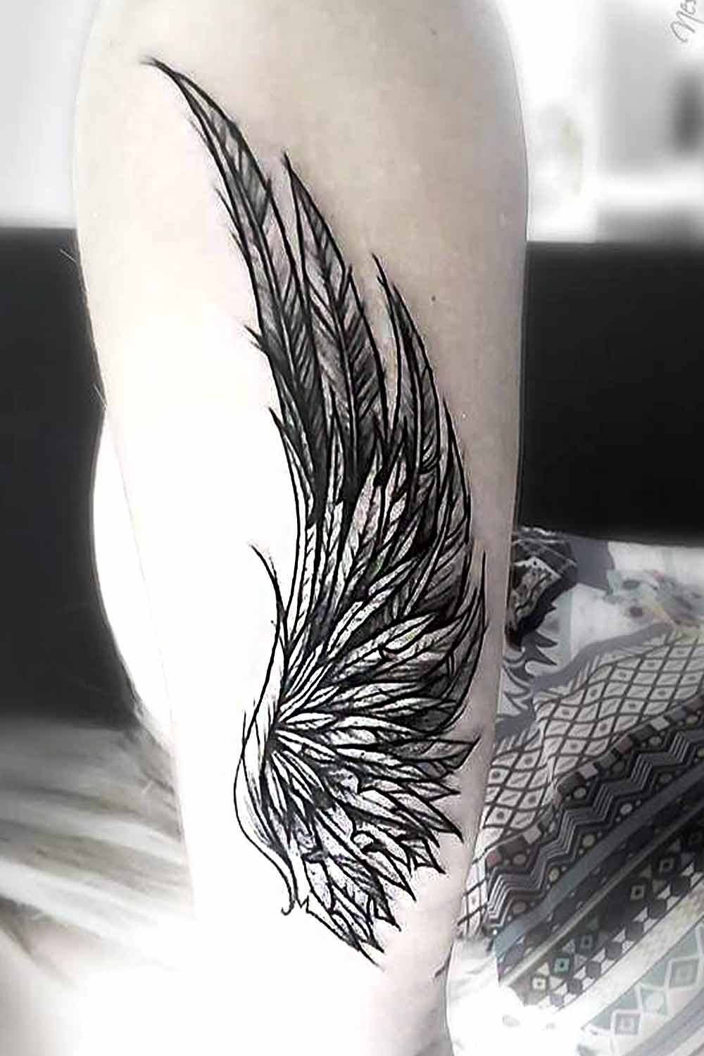 Premium Photo | A black and white angel wings tattoo with a black feather  on the left wing.